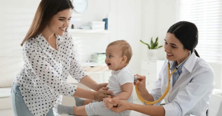 Physician assistant examines baby with mother watching